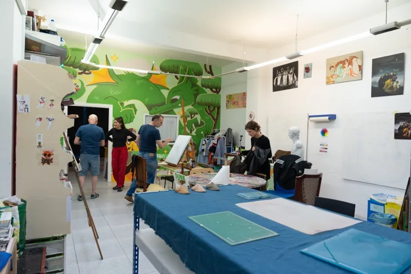 Estantería de materiales compartidos del taller, con pinceles, pinturas y papeles