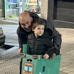 Un peque y un adulto sujetando el tren de cartón que han construido