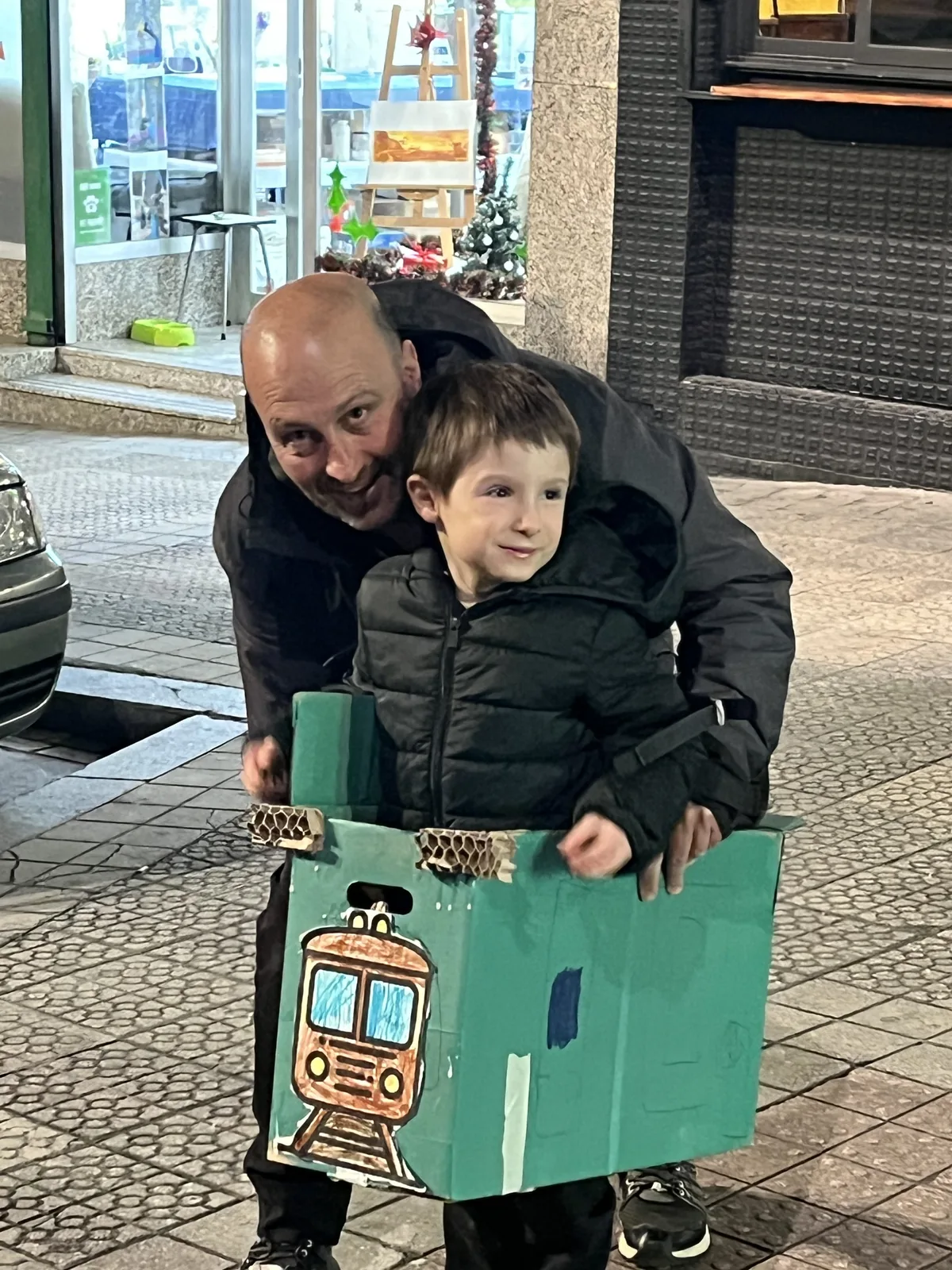 Un padre y su hijo con el tren de cartón que han hecho juntos en BiGGeR