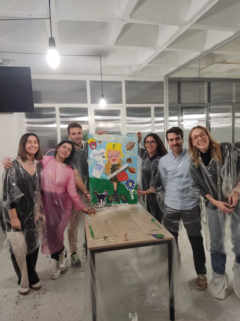 Equipo de una empresa posando con la obra que han pintado juntos en BiGGeR